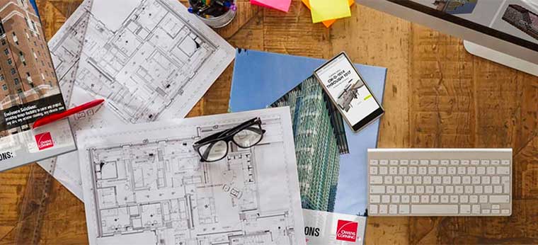 Blueprints and brochures on desk. Considering how Owens Corning products can work with your building project.