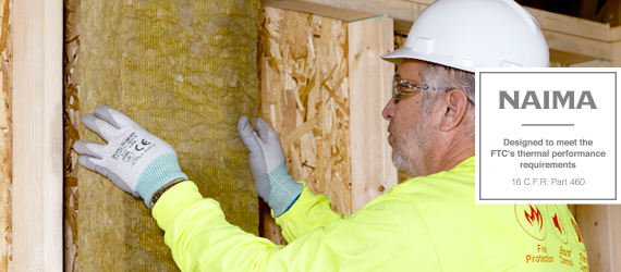 Man in yellow sweater installs insulation